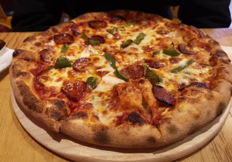Много начинки на пицце из Plaza Pizza Вкусная пицца в Plaza Pizza